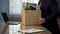 Employee putting his stuff from work desk in carton box, leaving job, retirement