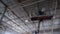 Employee stands in lifting cradle under ceiling of workshop