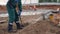 Employee in uniform throws soil at plant construction site