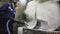 Employee works with hot steam jet to clean metal parts close