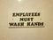 Employees must wash hands sign on white bathroom tile