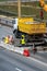 Employees of the road service in special yellow vests perform work on the repair of the roadway. Restoration of the deformation