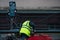 Employees of the road service in special yellow vests perform work on the repair of the roadway. Restoration of the deformation