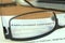 Employment contract behind glasses on a desk, 3D rendering