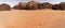 The emptiness of the great desert in the nature reserve of Wadi Rum, with large mountains of red sandstone in the background and t