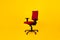 Empty Adjustable Ergonomic Office Chair With Armrests Over Yellow Background