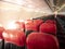 Empty aircraft cabin with female cabin crew working in galley. premium and economy seat row in cabin. red and black seat. Outstand