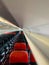 Empty aircraft cabin with male cabin crew working in galley. premium and economy seat row in cabin. red seat and black seat.