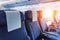 Empty aircraft seats and light shine porthole windows