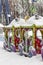 An empty amusement park in winter, a multi-colored carousel steam engine under a thick layer of snow. City leisure park for