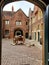 Empty ancient courtyard at Henry 8th& x27;s Hampton Court Palace framed by arched doorway and highlighting a cart