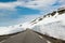 Empty asphalt mountain road with high snow level at July, Norway