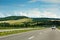 The empty asphalt road and blue sky with white clouds on the sunny day. Classic panorama view of road through fields