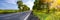 Empty asphalt road in countryside and fields at blue sky background