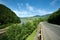 Empty asphalt road highway in the forested mountains, on sky