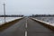 Empty asphalt road through winter agricultural fields