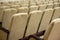 Empty auditorium with beige chairs, theatre or conference hall.