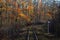 Empty autumn railway in the forest and mileage column