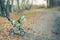 Empty baby stroller left in a park on autumn day