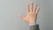 Empty back hand and five finger count in grey suit color on grey background. Businessman topic.close up photo and studio shooting