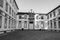 Empty backyard of ancient monastery in Europe monochrome. Monastery exterior with cross on roof black and white.