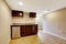 Empty basement room with dark brown kitchen cabinets