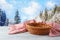 Empty basket with tablecloth on wooden table over winter landscape background.  Christmas and New Year mock up for design and