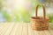 Empty basket on wooden table over green bokeh background. Spring and easter mock up for design