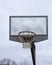 Empty basketball net against a dull blue sky