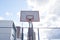 Empty basketballs hoop in city against blue sky.