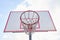 Empty basketballs hoop in city against blue sky.