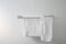 Empty bathroom with two white dry towel hanging on steel rail on white tile wal