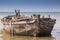 Empty beach, ancient boat in the sea