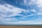 Empty beach with a blue sky and wispy cloudscape. Aldeburgh, Suffolk UK.