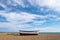 Empty beach, blue sky, wispy cloudscape, fishing boat. Aldeburgh, Suffolk UK.