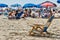 Empty Beach Chair on the Sand with People in Background