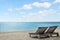 Empty beach chairs on empty tropical beach