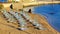 Empty beach chairs on sandy beach at reosrt Panormos in Crete island, Greece