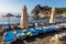 An empty beach in a heavenly bay. Beach umbrellas with sunbeds and towels on towels.