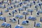 Empty beach loungers with folded blue umbrellas in summertime, Italy