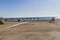 Empty beach with palapas on the shore and a game for children with the sea in the background