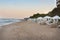 Empty beach on the seaside at the end of resort season with many empty sun loungers and umbrellas in the evening