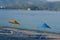 Empty beach with two umbrellas and sun beds. Boat on the horizon.