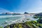 Empty beautiful beach during springtime on a sunny day with blue sky and silent ocean with small waves and snowy mountain chain