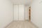 Empty bedroom with light wood flooring, plain white painted walls