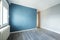 empty bedroom with plain green wall and gray parquet floors