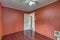 Empty bedroom with reddish brown orange walls dark wood tile floor white ceiling with fan