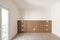 Empty bedroom with wooden headboard with attached wall sconces and matching tiled floors and plain white painted walls