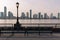 Empty Bench at Battery Park in New York City with a view of the Jersey City Skyline along the Hudson River