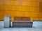 Empty bench with bins against wall